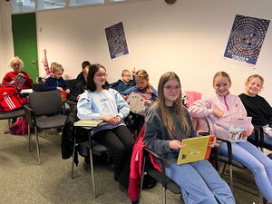 Kinder in Stuhlreihen sitzend