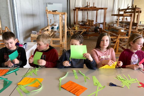 Schulkinder beim Basteln mit Papier