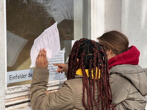 Kinder beim Anbringen von Zetteln an Fenster