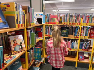 Kinder gehen in der Bücherei umher