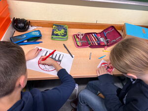 Schülerinnen und Schüler beim Zeichnen von Wappen