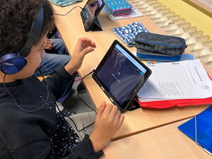 Schülerinnen und Schüler bei Lernen am Tablet