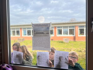 Kinder beim Anbringen von Zetteln an Fenster