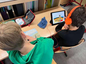 Kinder mit Tablets und Kopfhörern