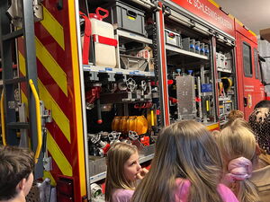 Schulkinder schauen auf das Feuerwehrfahrzeug