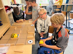 Schülerinnen und Schüler beim Experimentieren mit Beebots