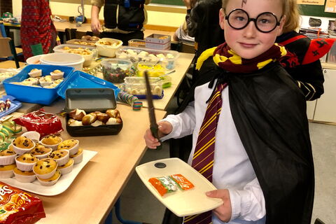 Verkleideter Junge am Kuchenbuffet