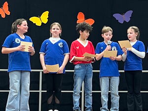 5 Kinder auf dem Podium tragen etwas vor