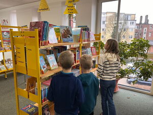 Kinder gehen in der Bücherei umher