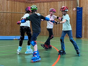 Kinder beim Inlineskaten in der Turnhalle
