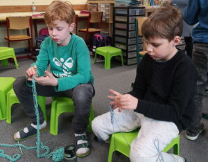 Schülerinnen und Schüler beim Arbeiten mit Wollfäden