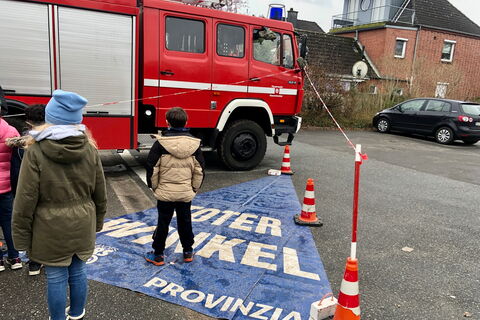 Schulklasse mit Feuerwehrfahrzeug