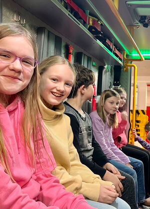 Schulkinder sitzen im Feuerwehrfahrzeug