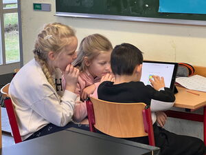 Drei Kinder vor einem Arbeitsheft