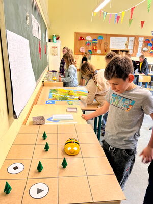 Schülerinnen und Schüler beim Experimentieren mit Beebots