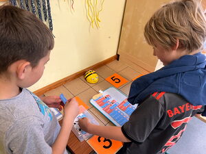 Schülerinnen und Schüler beim Experimentieren mit Beebots