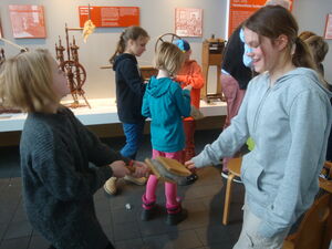 Kinder beim Kämmen von roher Wolle