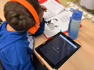 Schülerinnen und Schüler bei Lernen am Tablet