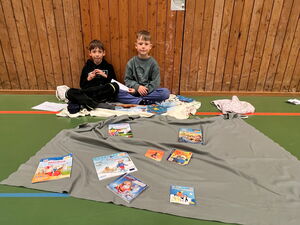 Schulkinder beim Bücherflohmarkt in der Turnhalle