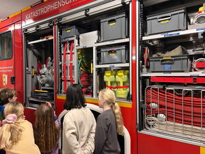 Schulkinder schauen auf das Feuerwehrfahrzeug