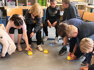 Schülerinnen und Schüler beim Experimentieren mit Beebots