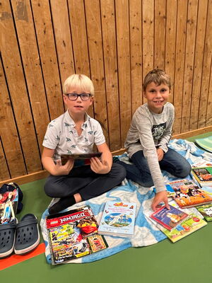 Schulkinder beim Bücherflohmarkt in der Turnhalle