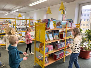 Kinder gehen in der Bücherei umher