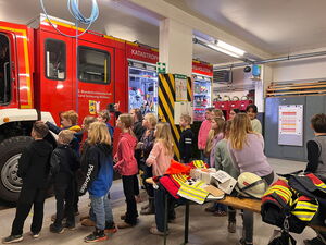 Schulkinder in der Halle schauen auf das Feuerwehrfahrzeug