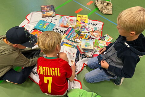 Kinder beim Flohmarkt mit Büchern