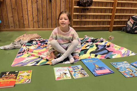 Mädchen beim Flohmarkt mit Büchern