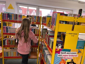 Kinder gehen in der Bücherei umher