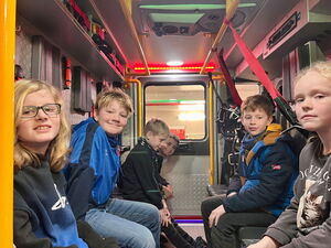 Schulkinder sitzen im Feuerwehrfahrzeug