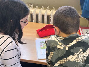 Zwei Kinder vor einem Arbeitsheft