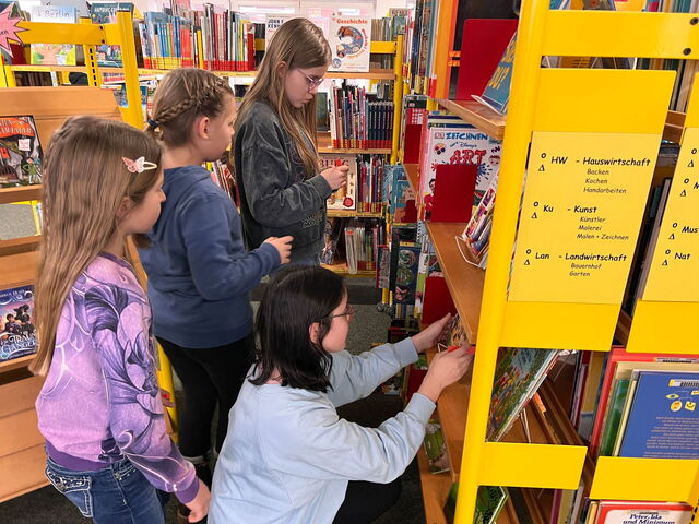 Kinder gehen in der Bücherei umher