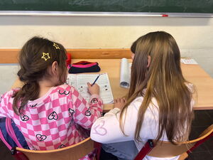 Zwei Kinder vor einem Arbeitsheft