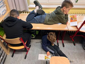 Kinder beim Lesen am, unter und auf dem Tisch