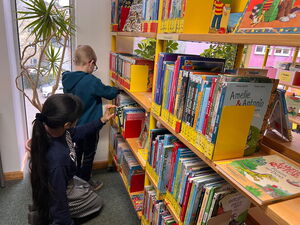 Kinder gehen in der Bücherei umher