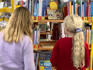 Kinder gehen in der Bücherei umher